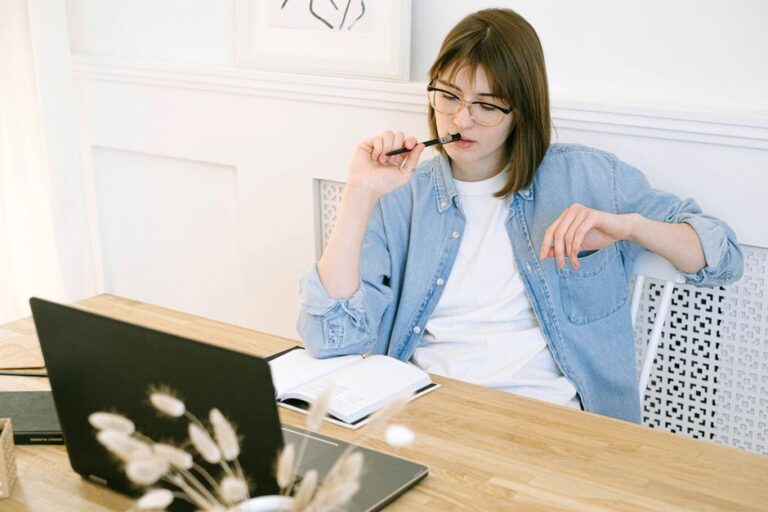 woman thinking at laptop desk