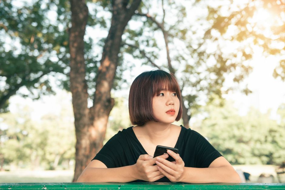 Personne en tenue professionnelle utilisant un ordinateur portable et un smartphone pour récupérer son compte