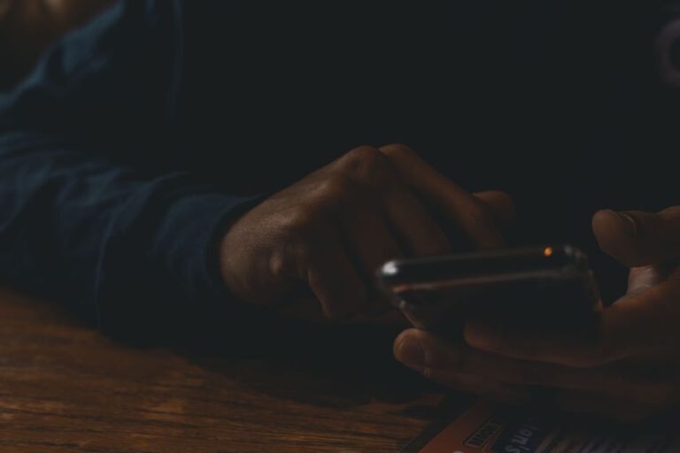 person scrolling phone in dark room