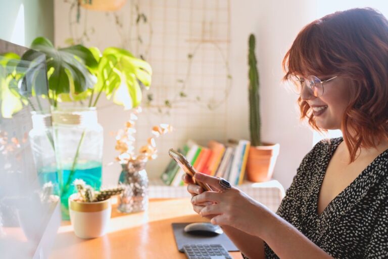 woman holding smartphone at desk