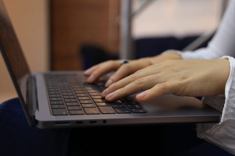 hands typing on laptop keyboard