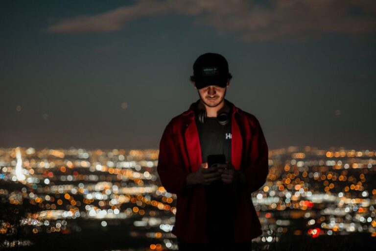 young man using phone at night street