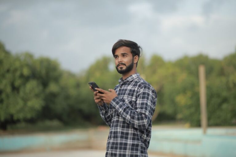 young man looking at smartphone outdoors