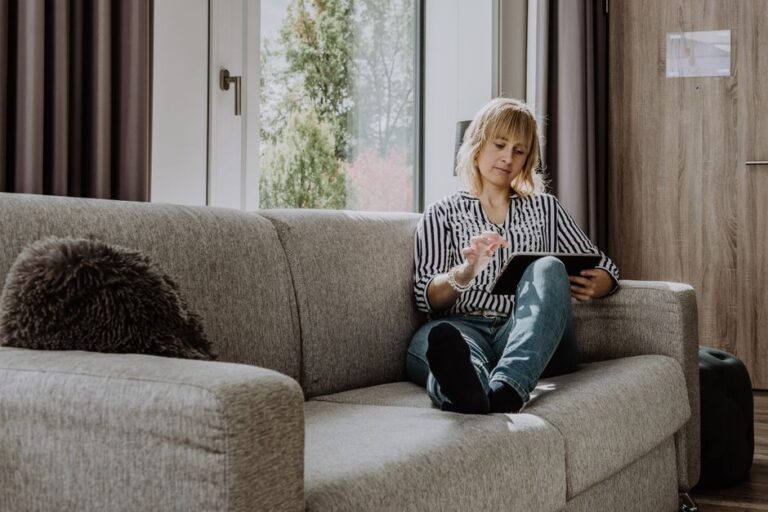 woman using tablet on sofa