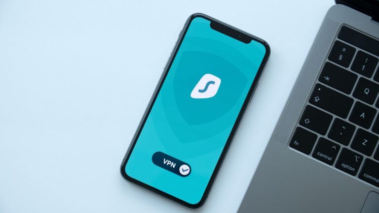 Téléphone intelligent affichant une application VPN à côté d'un ordinateur portable