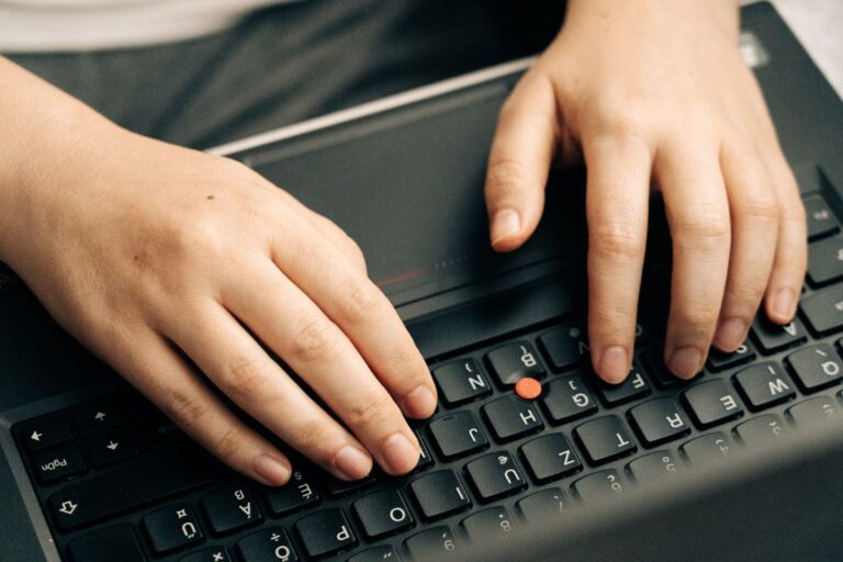 Mains tapant un mot de passe sur un clavier d'ordinateur portable