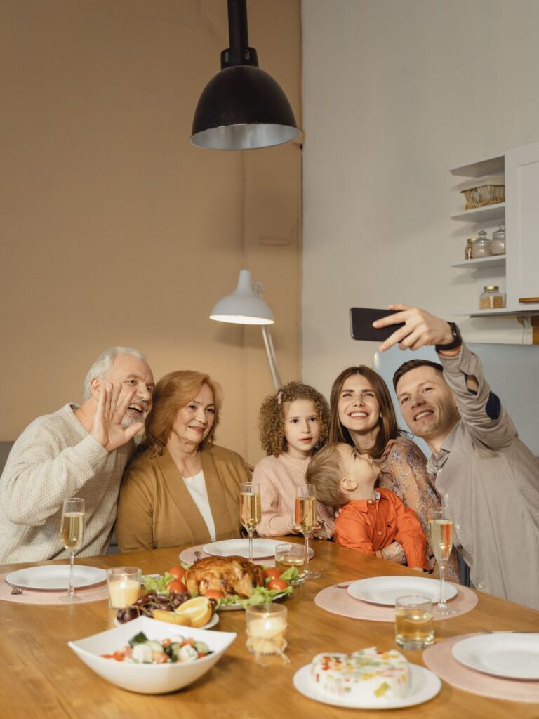 Famille souriante prenant un égoportrait lors d'un souper festif