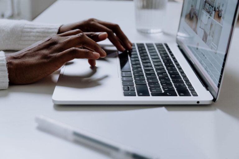 Mains tapant sur le clavier élégant d'un ordinateur portable