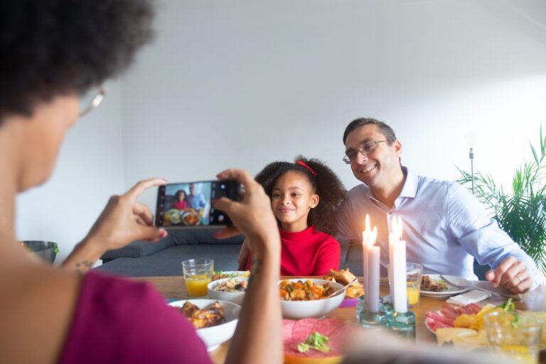 Femme photographiant un homme et une fillette lors d'un souper