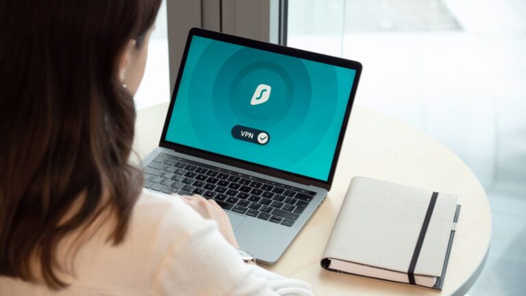 Femme travaillant sur un MacBook avec une icône VPN à l'écran