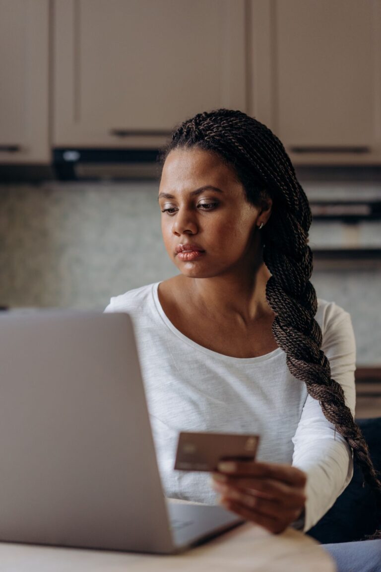 Femme tenant une carte de crédit en magasinant en ligne