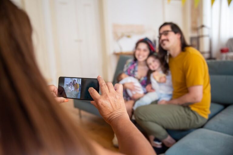 Famille posant pour une photo avec un téléphone intelligent à l'intérieur